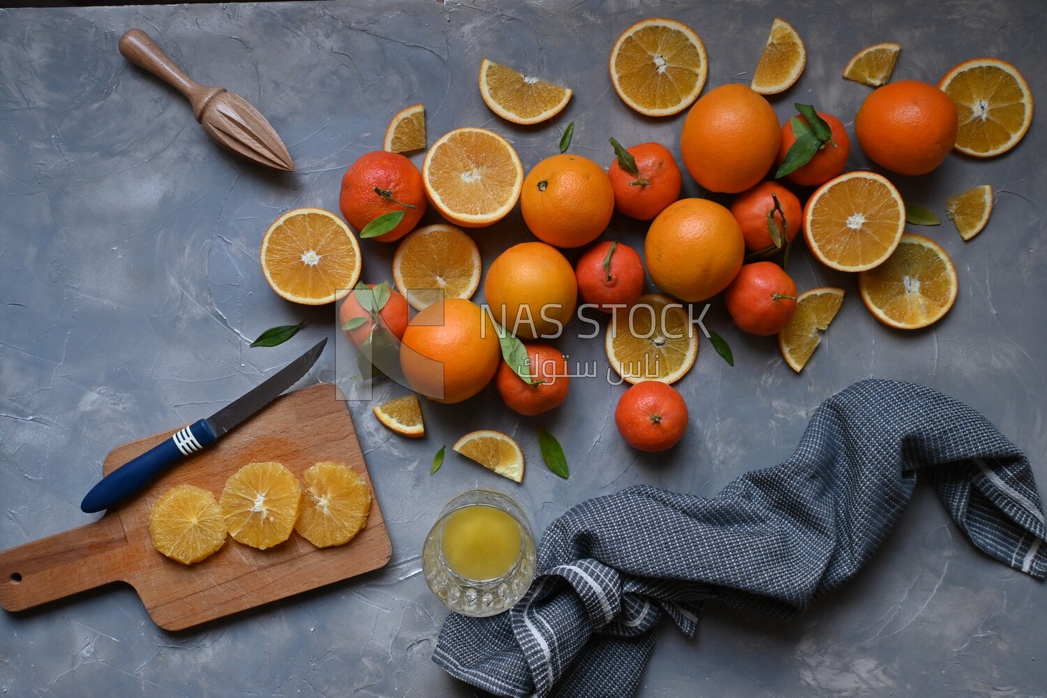 Oranges with a knife and orange slices on the table ​
