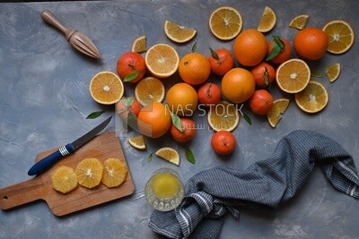 Oranges with a knife and orange slices on the table ​