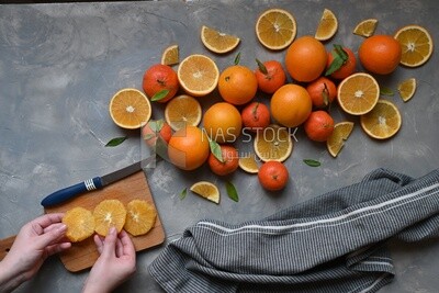 Oranges with a knife and orange slices on the table ​