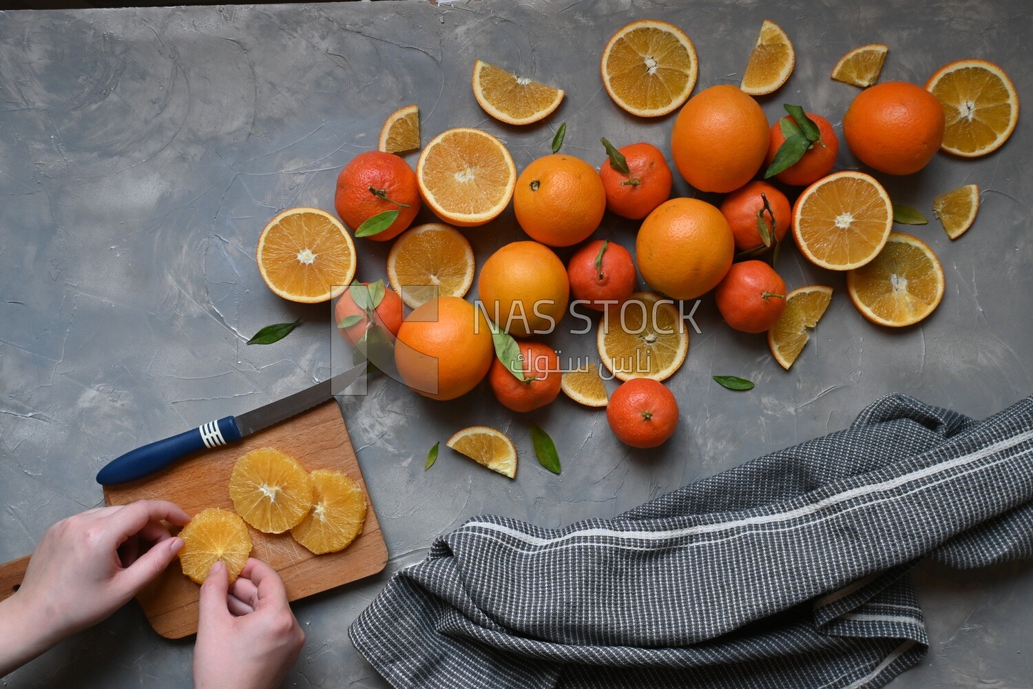 Oranges with a knife and orange slices on the table ​
