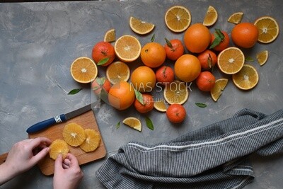 Oranges with a knife and orange slices on the table ​