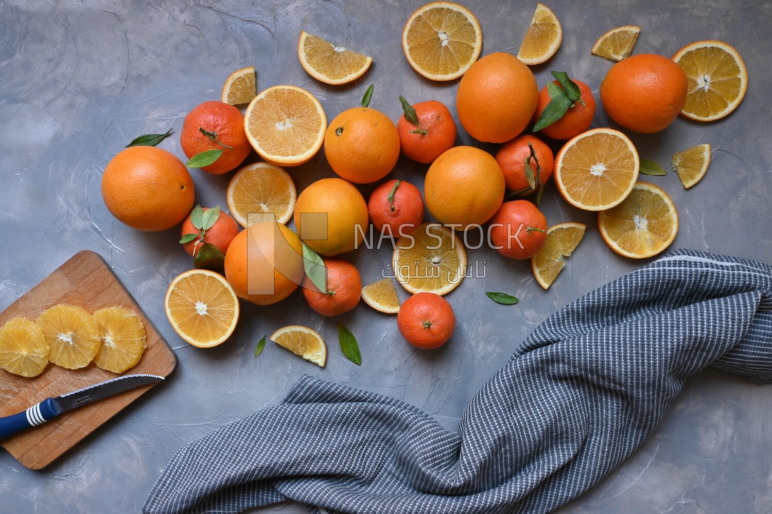 Oranges with a knife and orange slices on the table ​