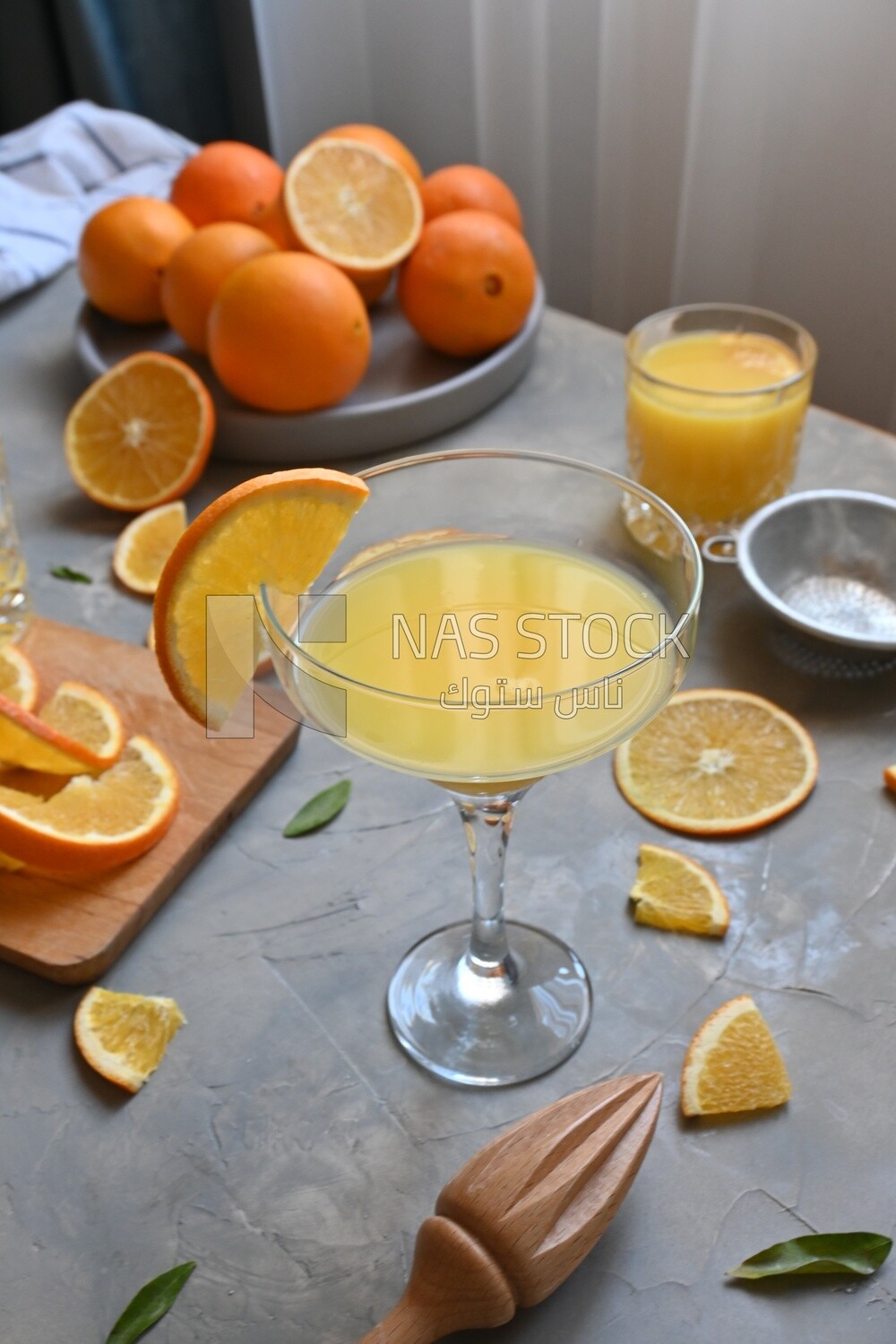 Glass of orange juice with a wooden citrus juicer