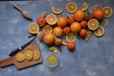 Oranges with a knife and orange slices on the table ​