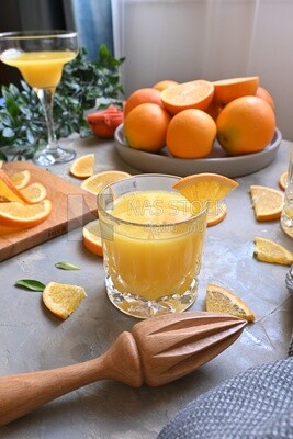 Glass of orange juice with a wooden citrus juicer