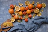 Oranges with a knife and orange slices on the table ​