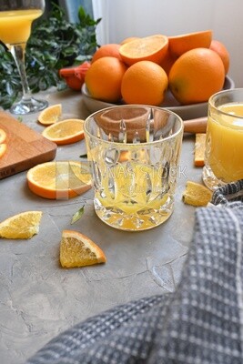 Glass of orange juice with a wooden citrus juicer