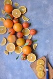 Oranges with a knife and orange slices on the table