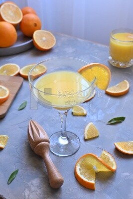 Glass of orange juice with a wooden citrus juicer