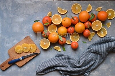 Oranges with a knife and orange slices on the table ​
