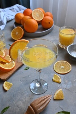 Glass of orange juice with a wooden citrus juicer