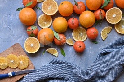 Oranges with a knife and orange slices on the table ​