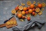 Oranges with a knife and orange slices on the table ​