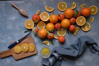 Oranges with a knife and orange slices on the table
