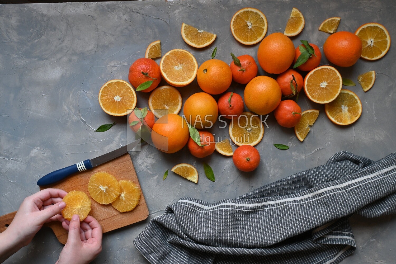 Oranges with a knife and orange slices on the table