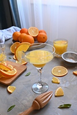 Glass of orange juice with a wooden citrus juicer