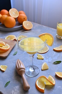 Glass of orange juice with a wooden citrus juicer