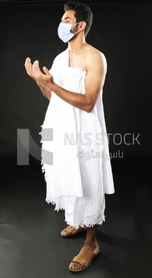 A man wearing an ihram dress with a mask