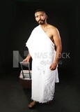 A man wearing an ihram dress with his luggage