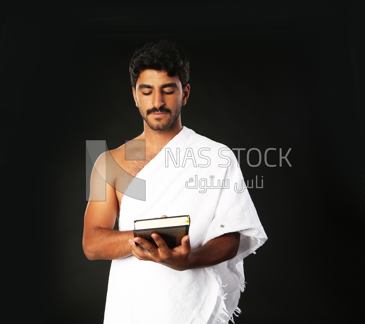 A man wearing an ihram dress prays