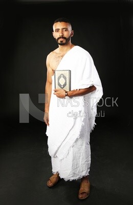 A man wearing an ihram dress prays