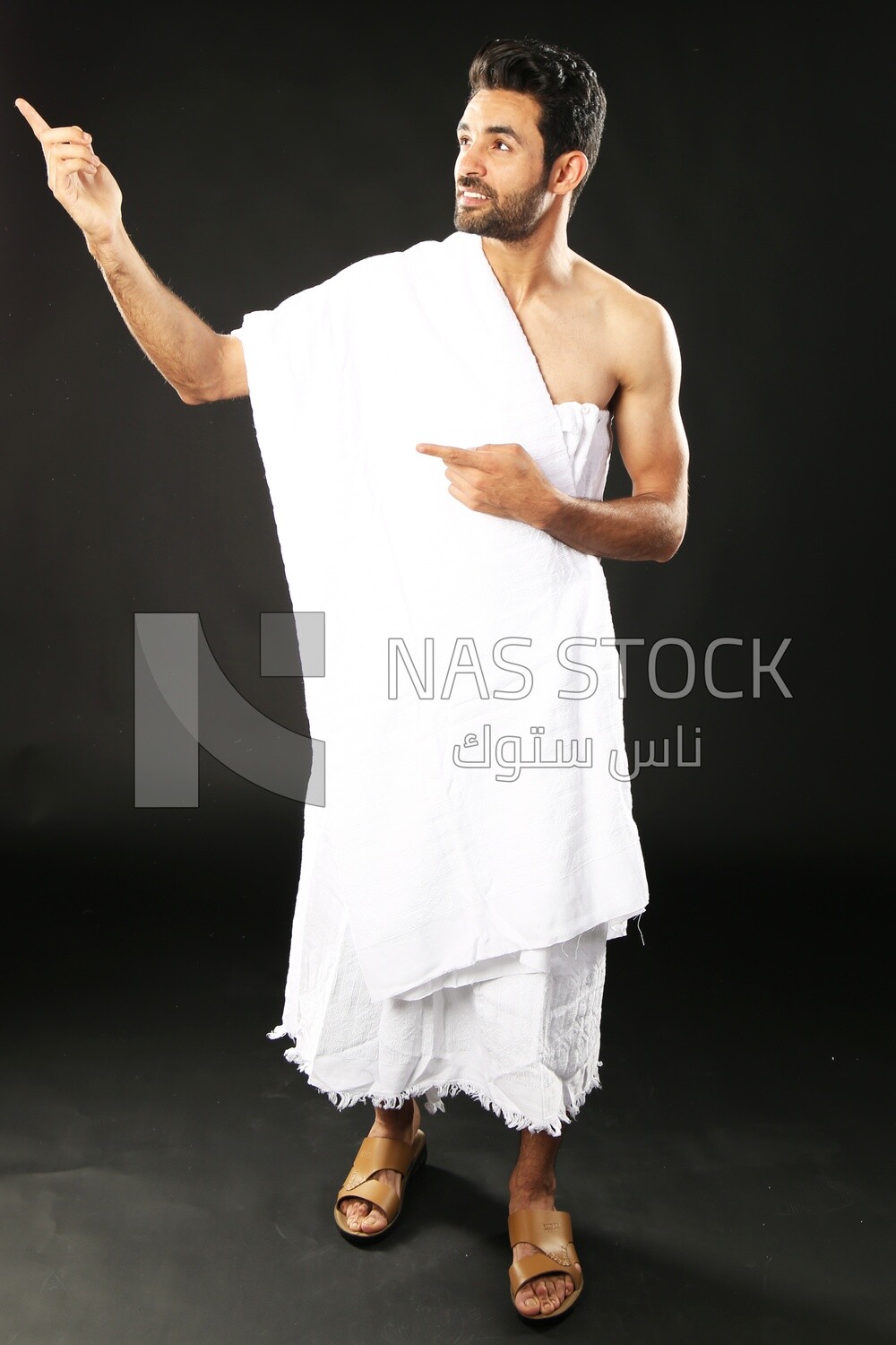 A man wearing an ihram dress pointing away