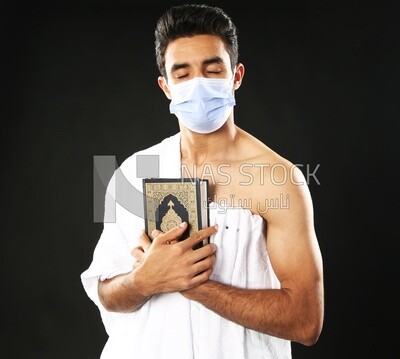 A man wearing an ihram dress prays