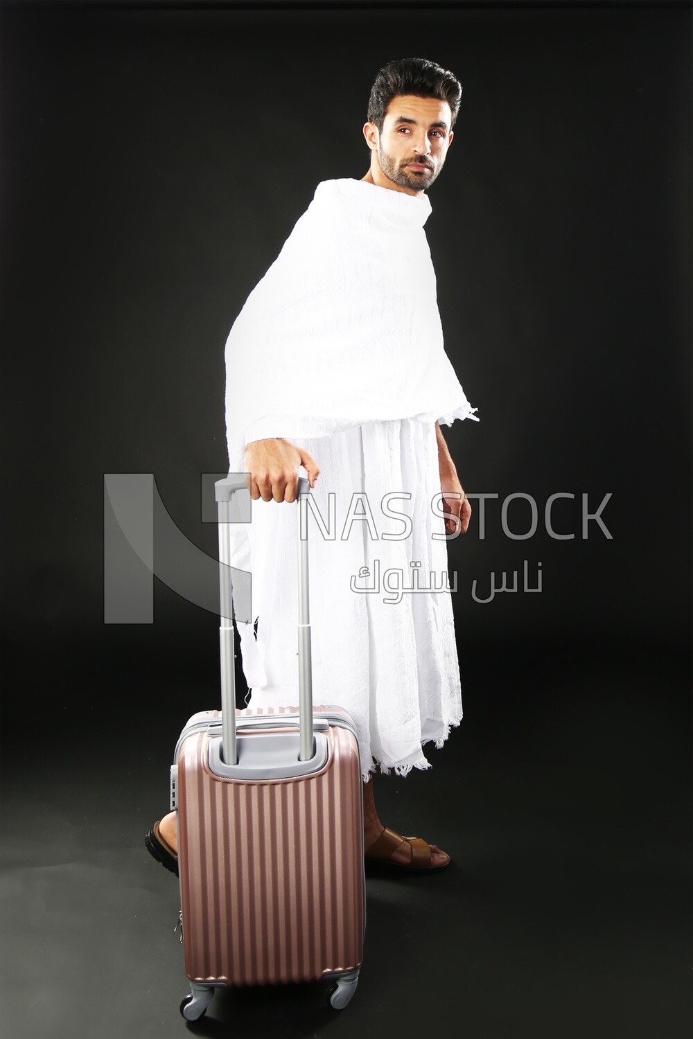 A man wearing an ihram dress with his luggage