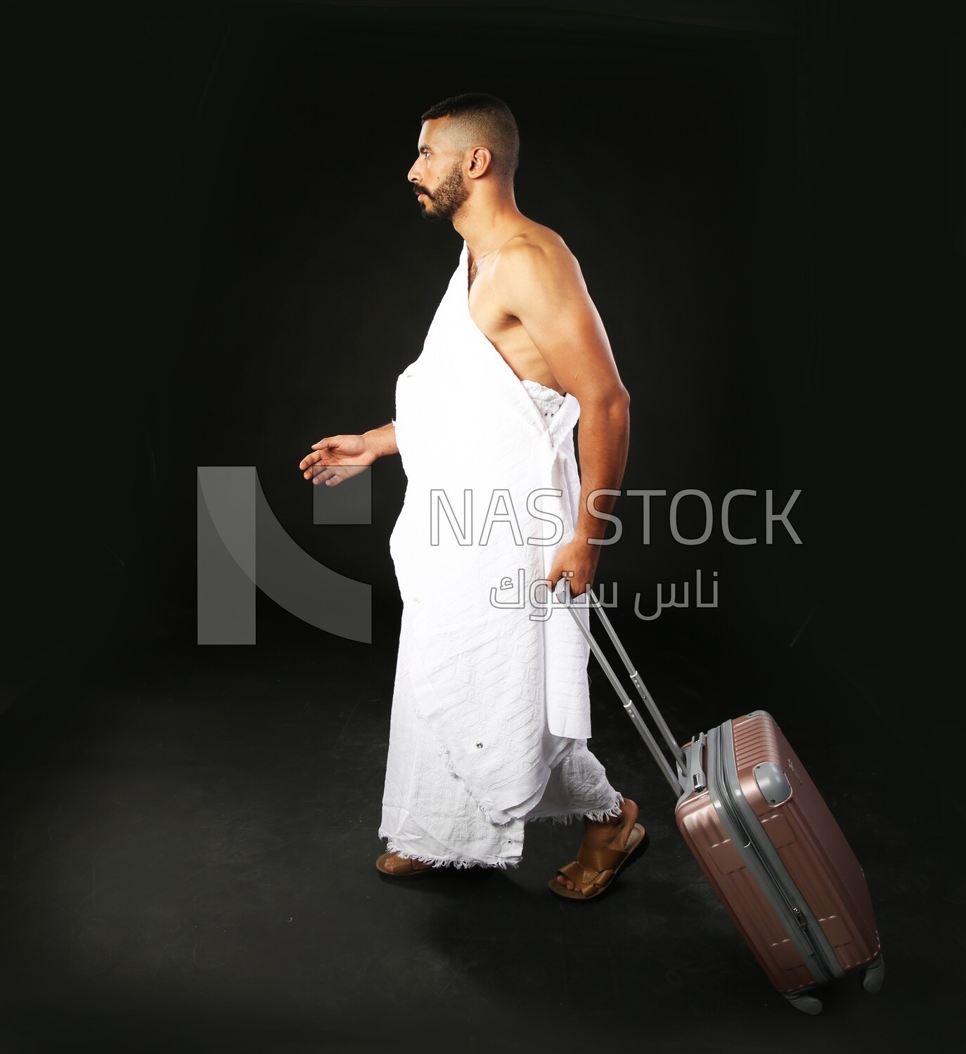 A man wearing an ihram dress with his luggage