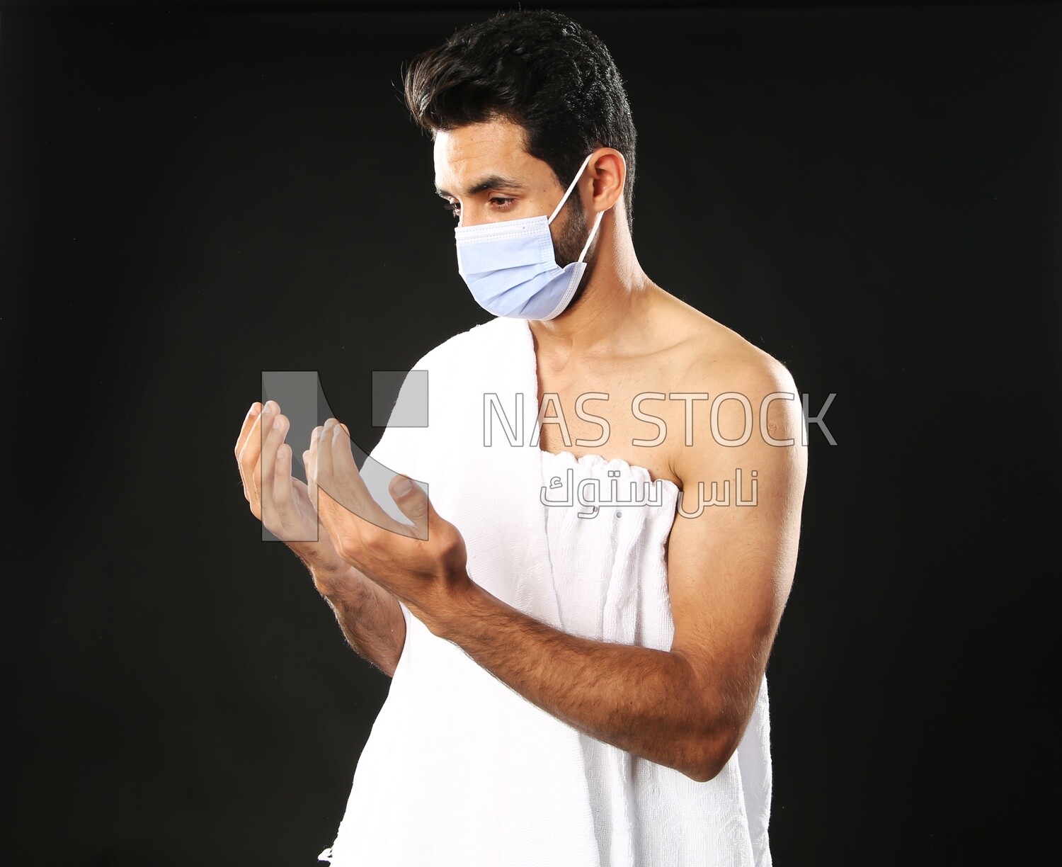 A man wearing an ihram dress with a mask
