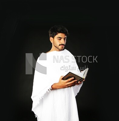 A man wearing an ihram dress prays