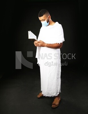 A man wearing an ihram dress prays