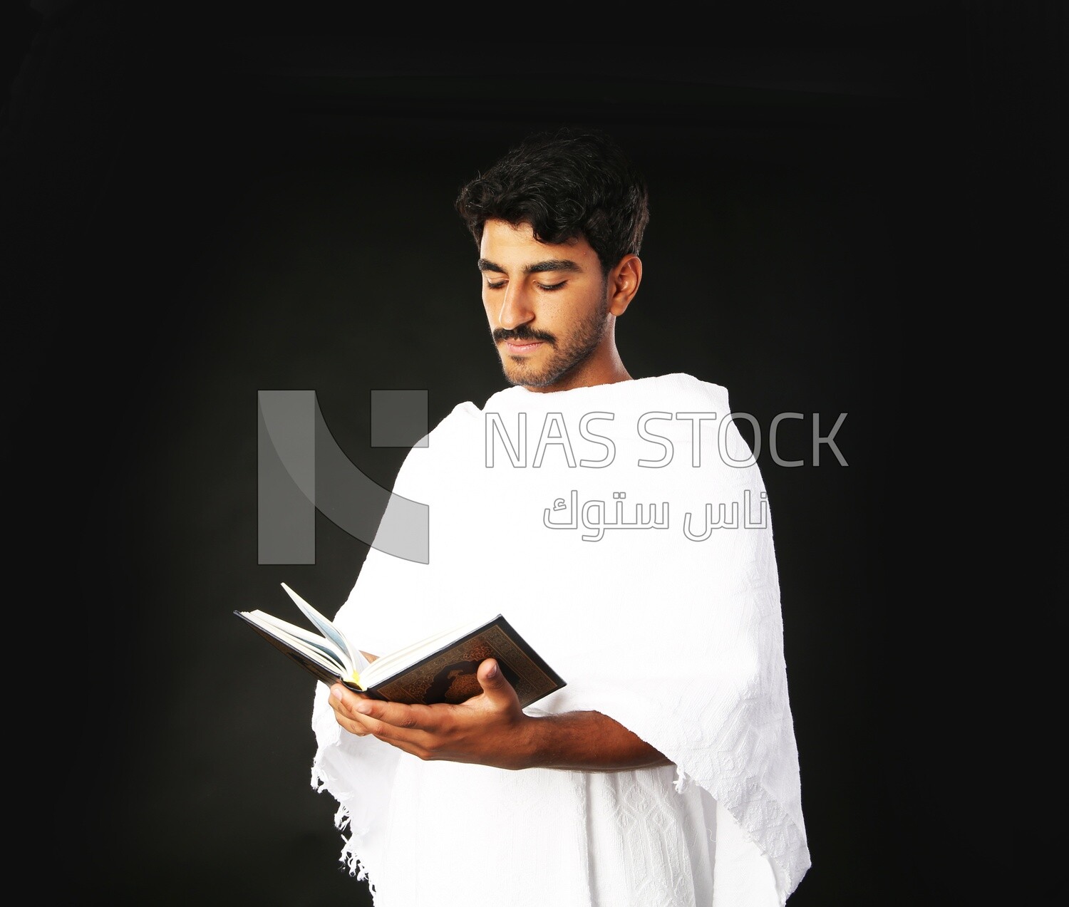 A man wearing an ihram dress prays