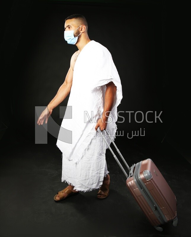 A man wearing an ihram dress with his luggage