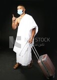 A man wearing an ihram dress with his luggage