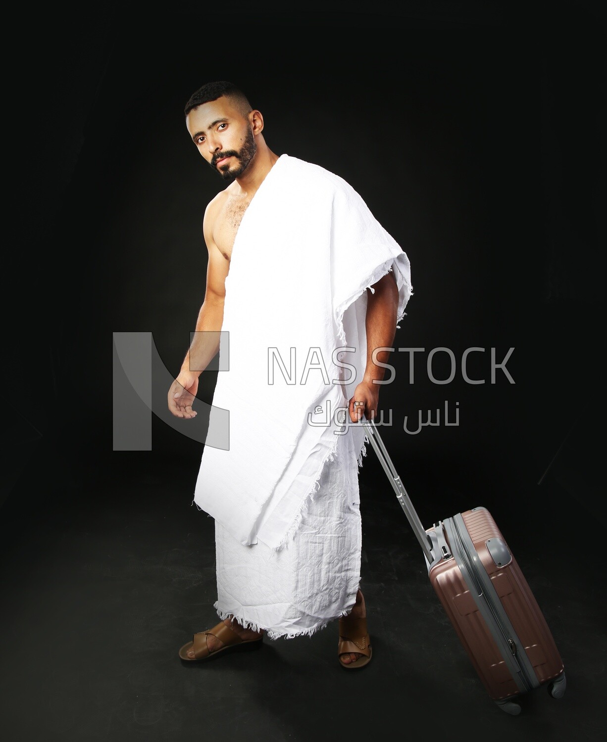 A man wearing an ihram dress with his luggage