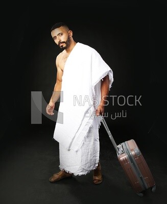 A man wearing an ihram dress with his luggage