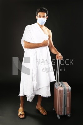 A man wearing an ihram dress with his luggage