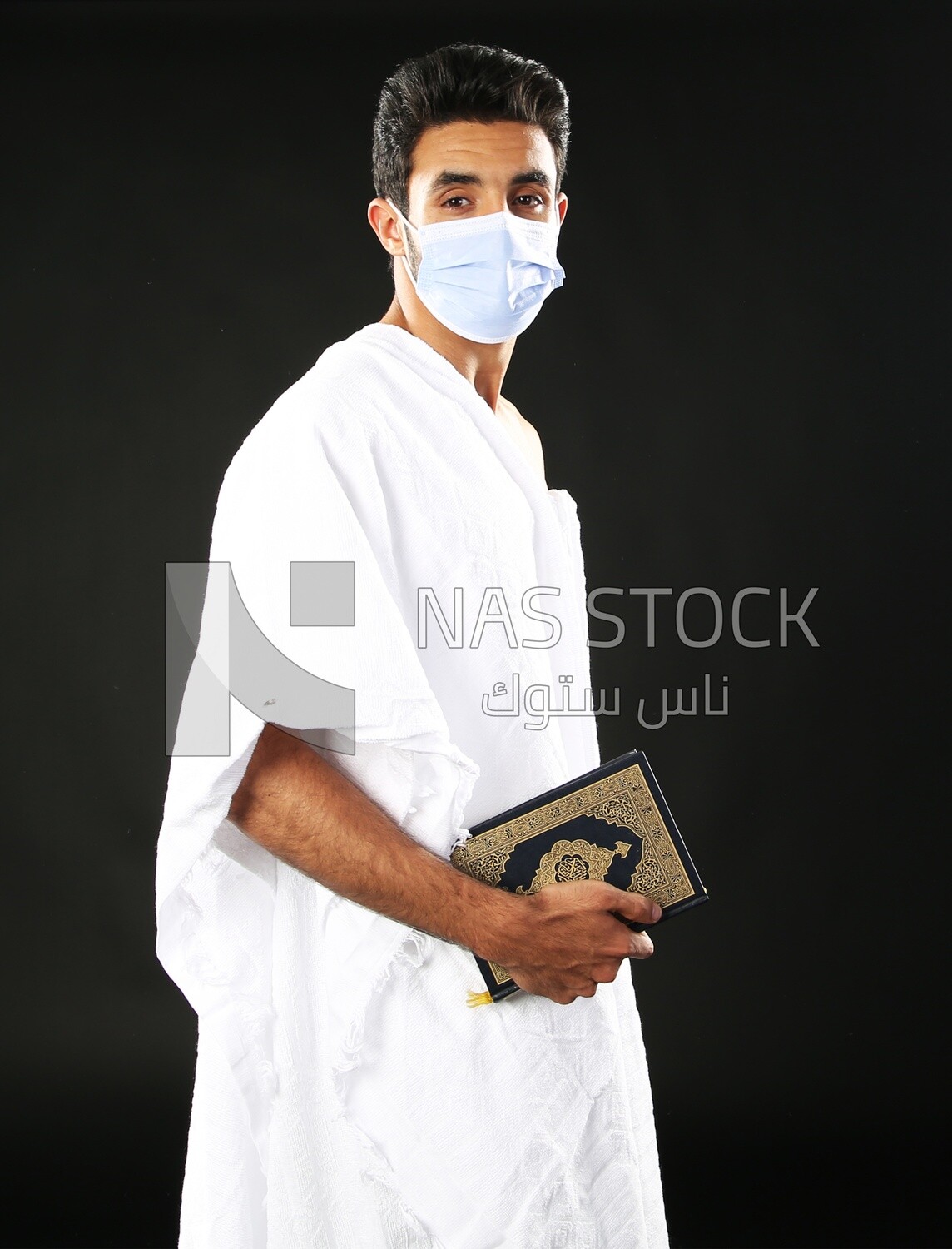 A man wearing an ihram dress prays