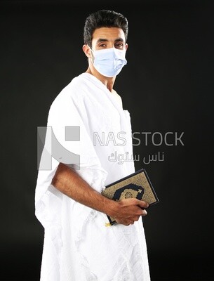 A man wearing an ihram dress prays