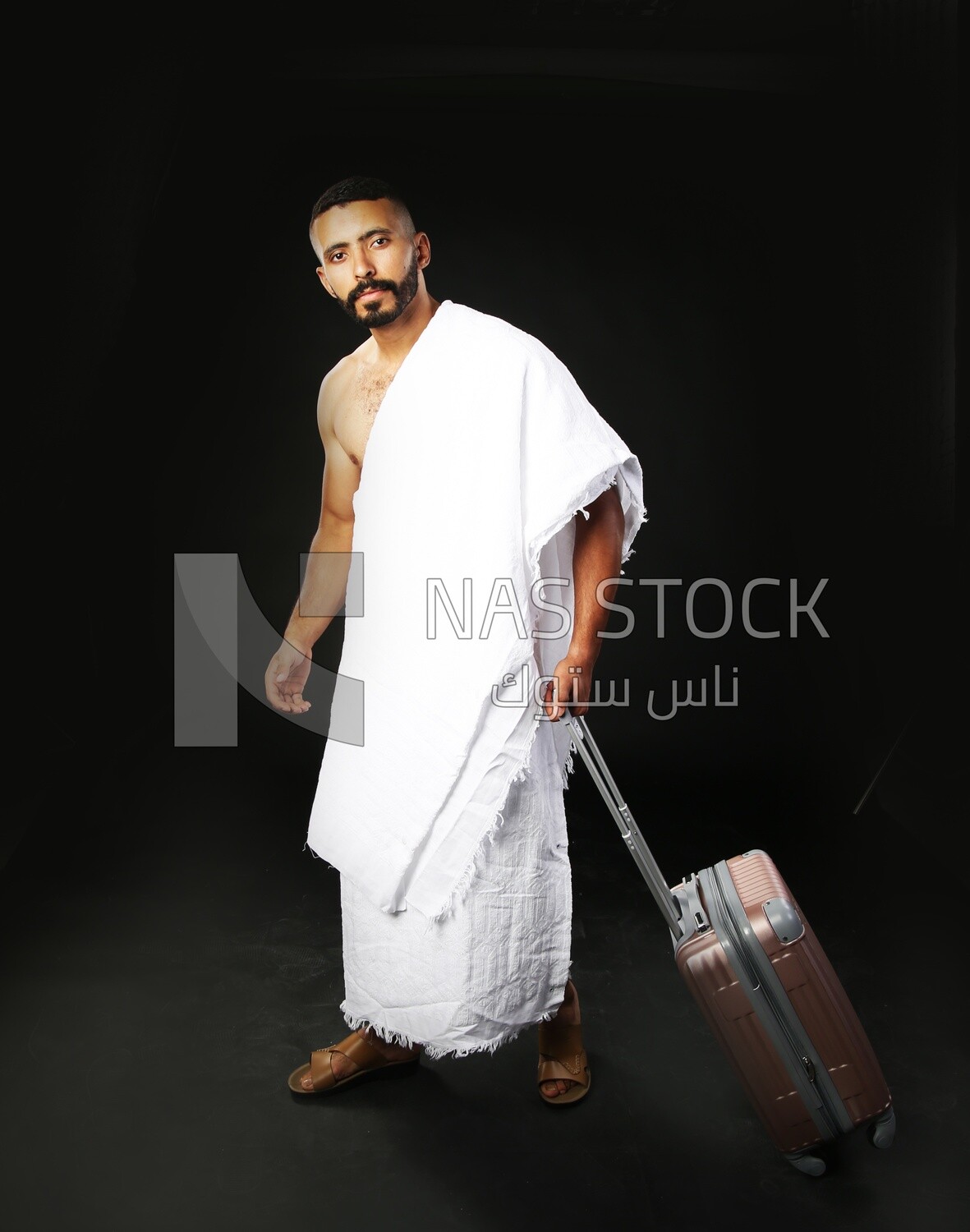 A man wearing an ihram dress with his luggage