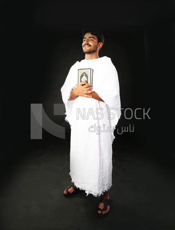 A man wearing an ihram dress prays