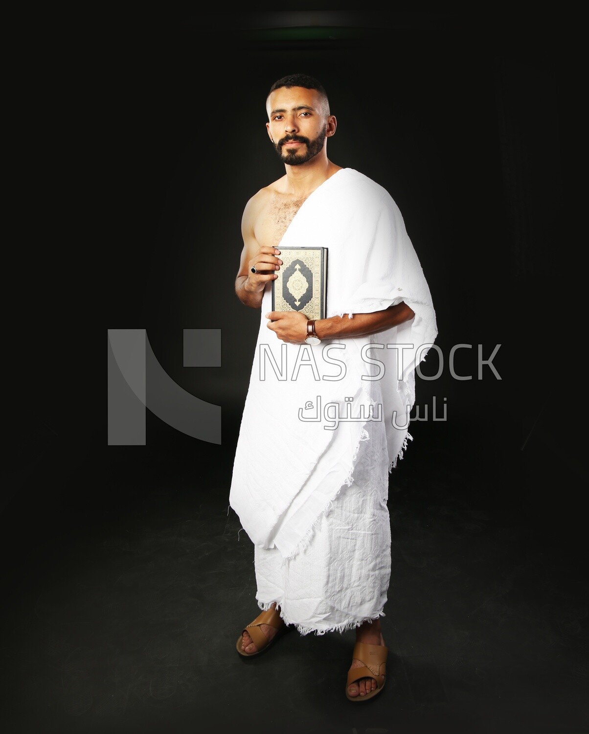 A man wearing an ihram dress prays