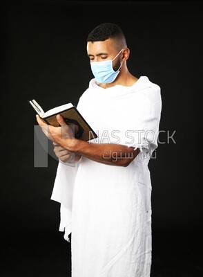 A man wearing an ihram dress prays