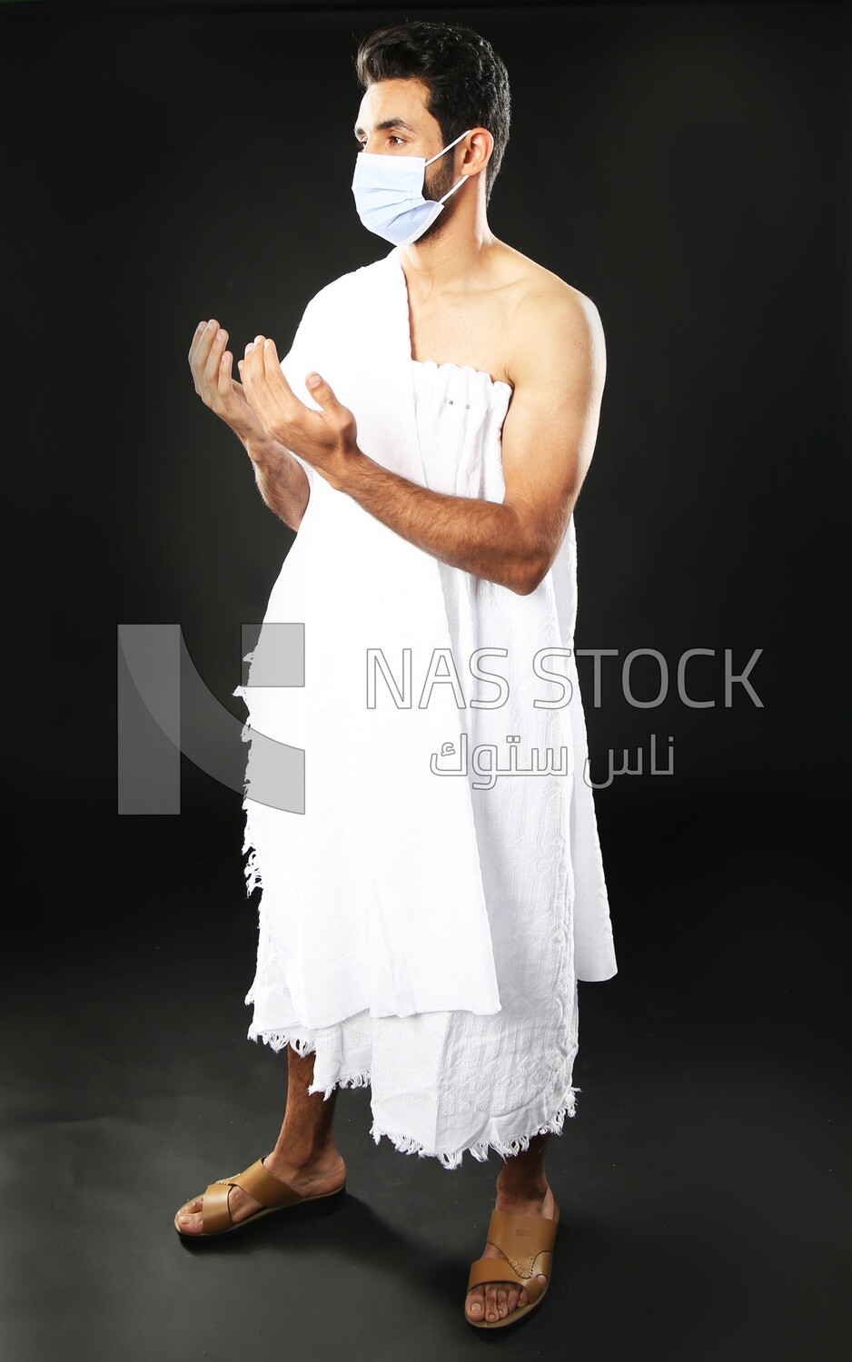 A man wearing an ihram dress with a mask