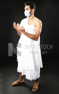 A man wearing an ihram dress with a mask