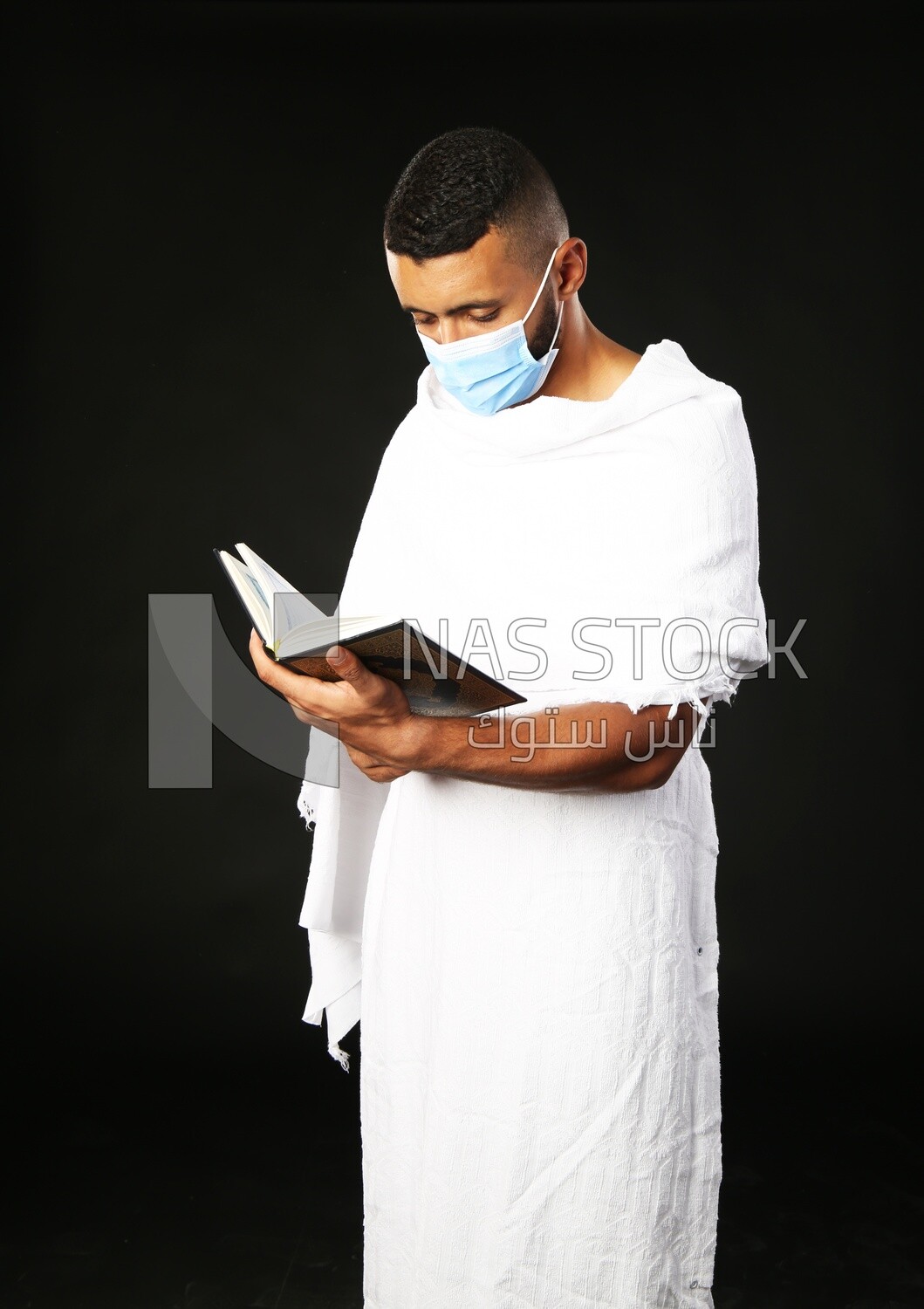 A man wearing an ihram dress prays