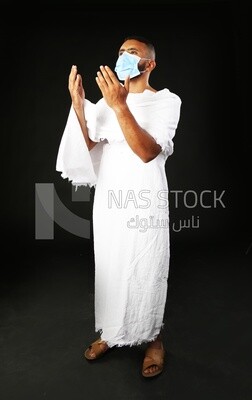 A man wearing an ihram dress with a mask