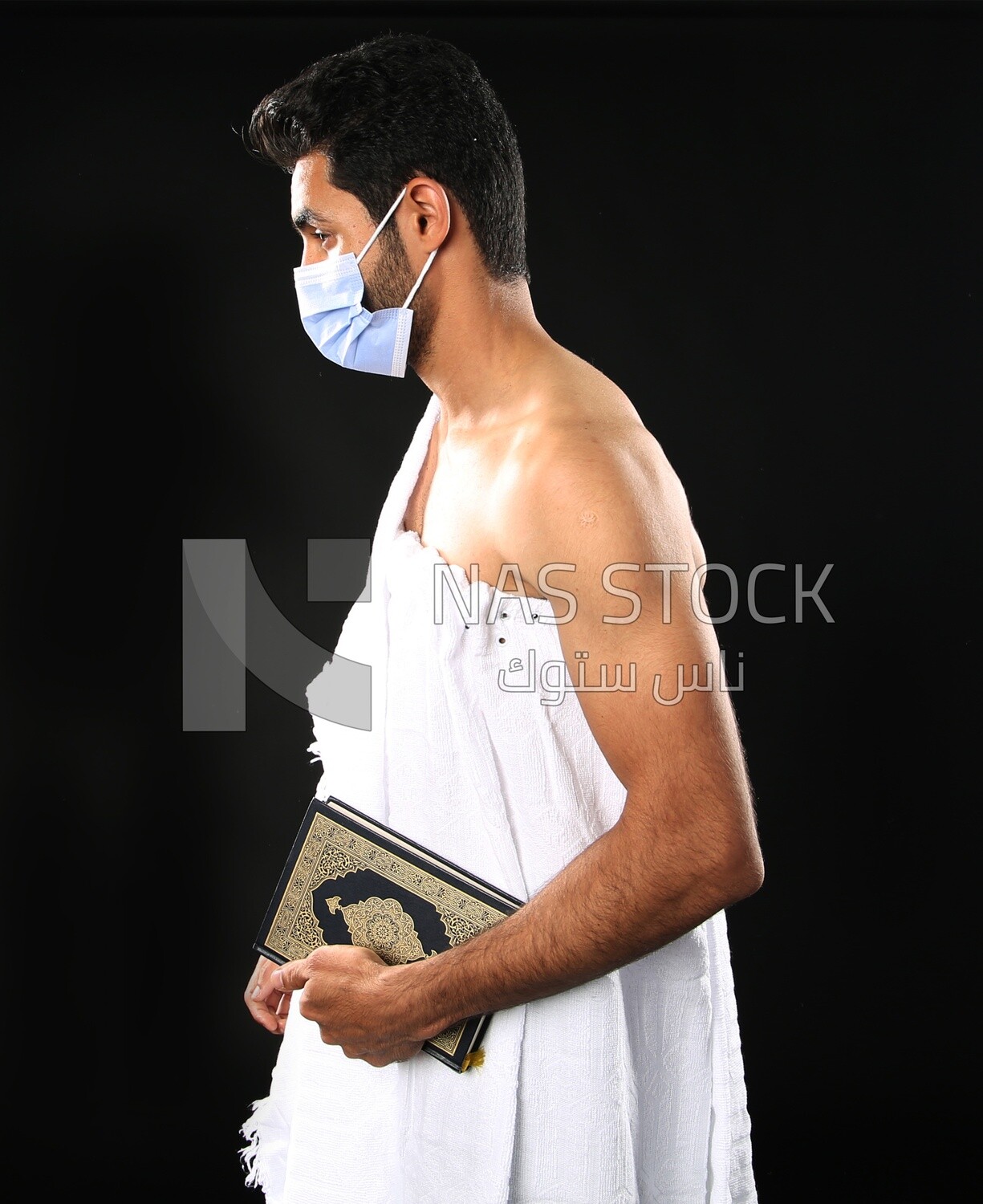 A man wearing an ihram dress prays