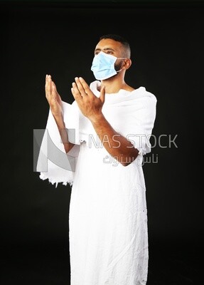 A man wearing an ihram dress with a mask